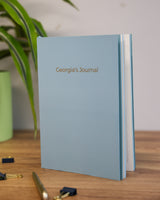 Blue notebook with "Georgia's Journal" in gold foil
